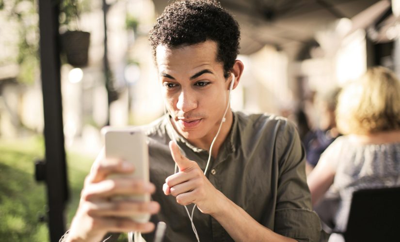 A young man is communicating with another person on his smartphone / X is introducing audio and video calls for Android users.